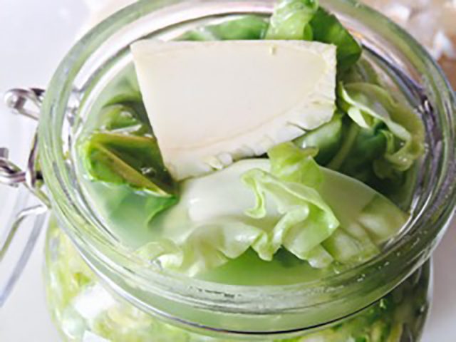 Lay down an outer leaf on top like a cover, then place a piece of cabbage core to further push in the cabbage once the lid is closed.