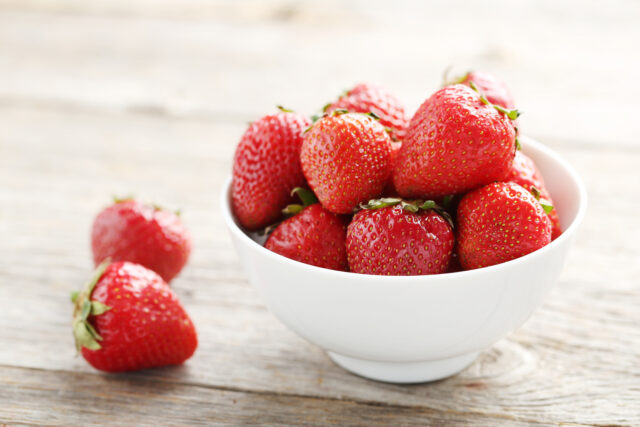 Fresh and tasty strawberries in bowl on a grey wooden table_Me So Sweet: 4 Unconventional and Delicious Ways to Enjoy Miso as a Dessert：haccola　Japanese fermented foods and cuisine