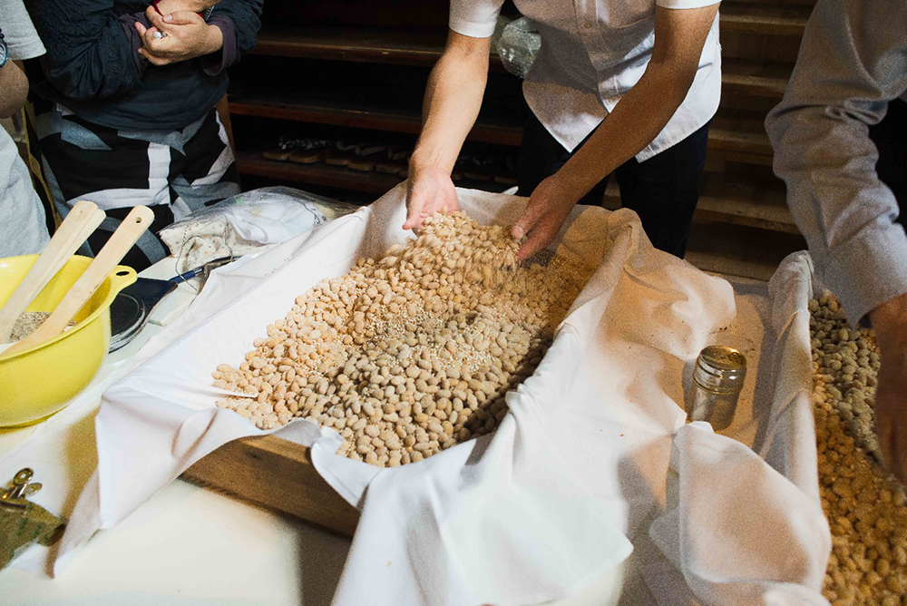 麹菌を大豆に混ぜ込んでいく